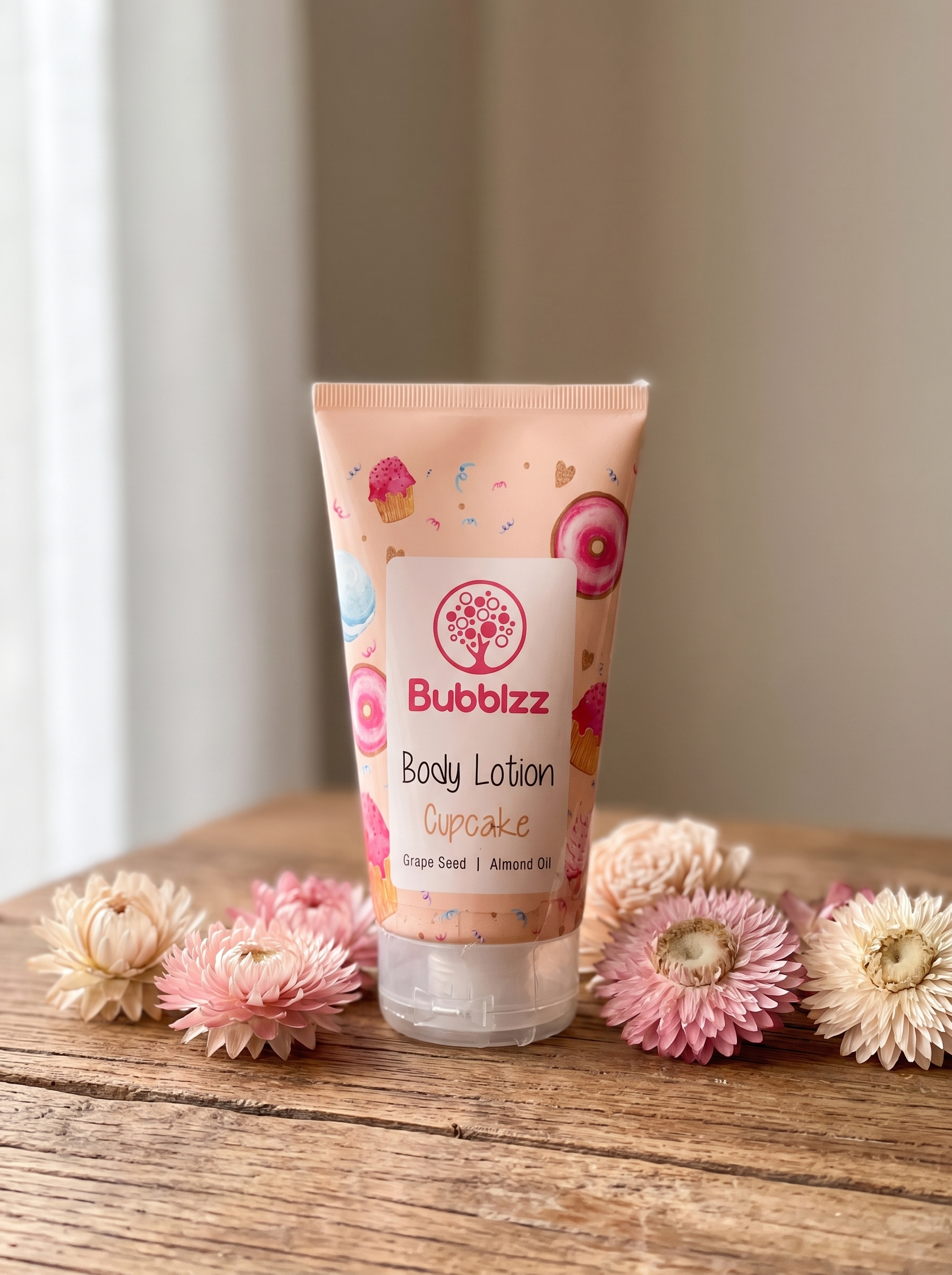Bubblzz Cupcake scented body lotion tube with grape seed and almond oil, styled with dried flowers